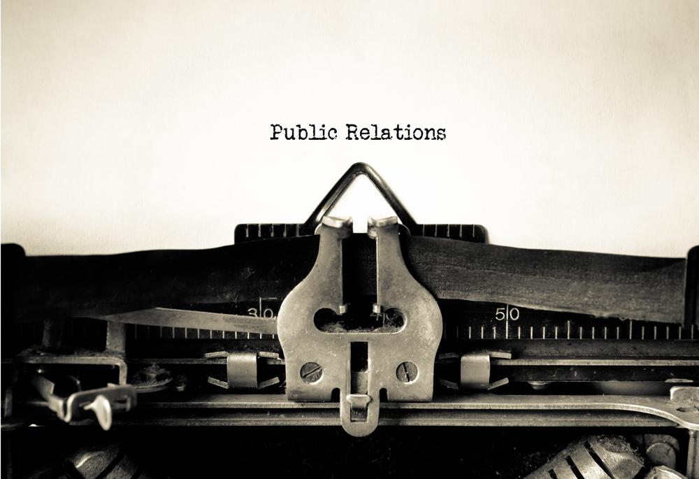 A typewriter types, "Public Relations."