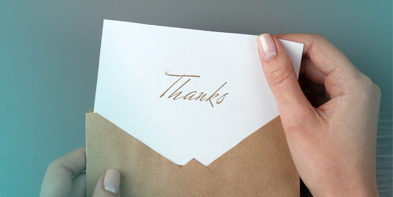 A woman removes a letter from an envelope, and the letter says, "Thanks."
