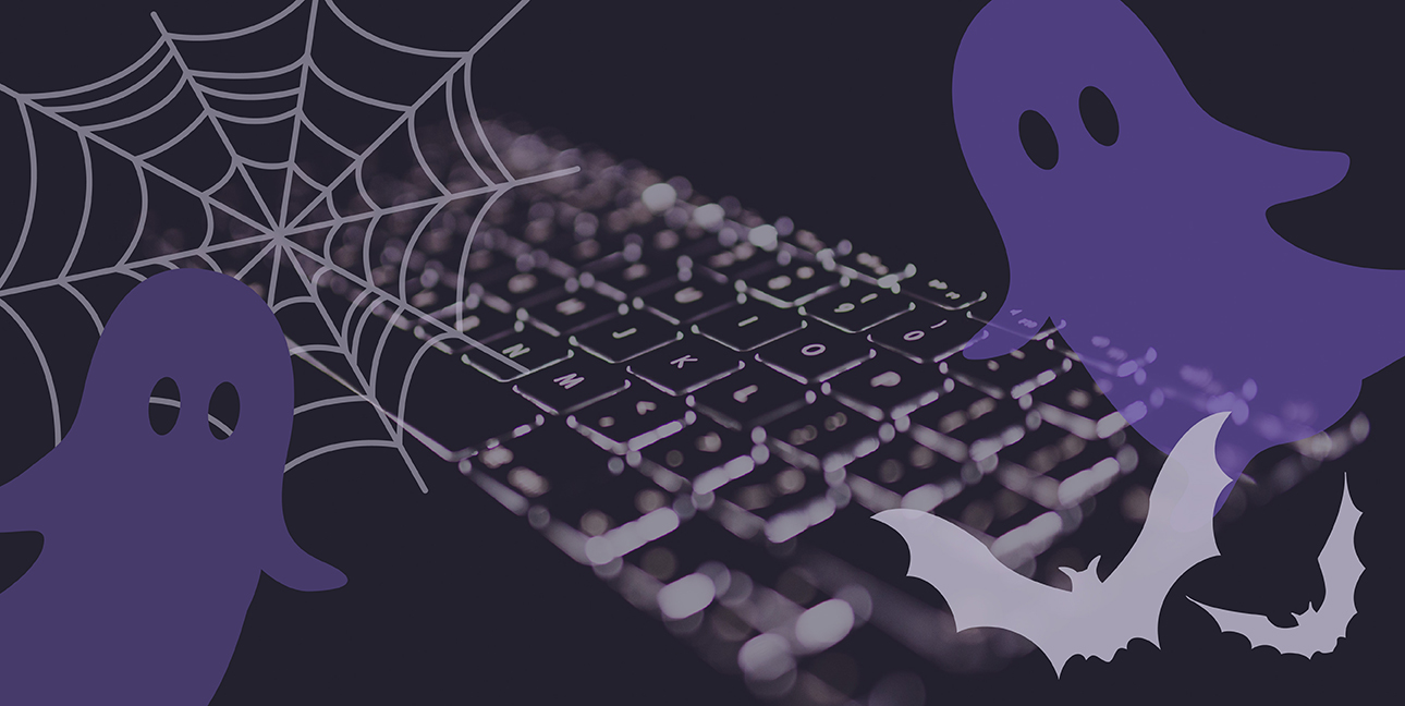 A black keyboard with cartoon ghosts, bats, and a spiderweb superimposed over it.