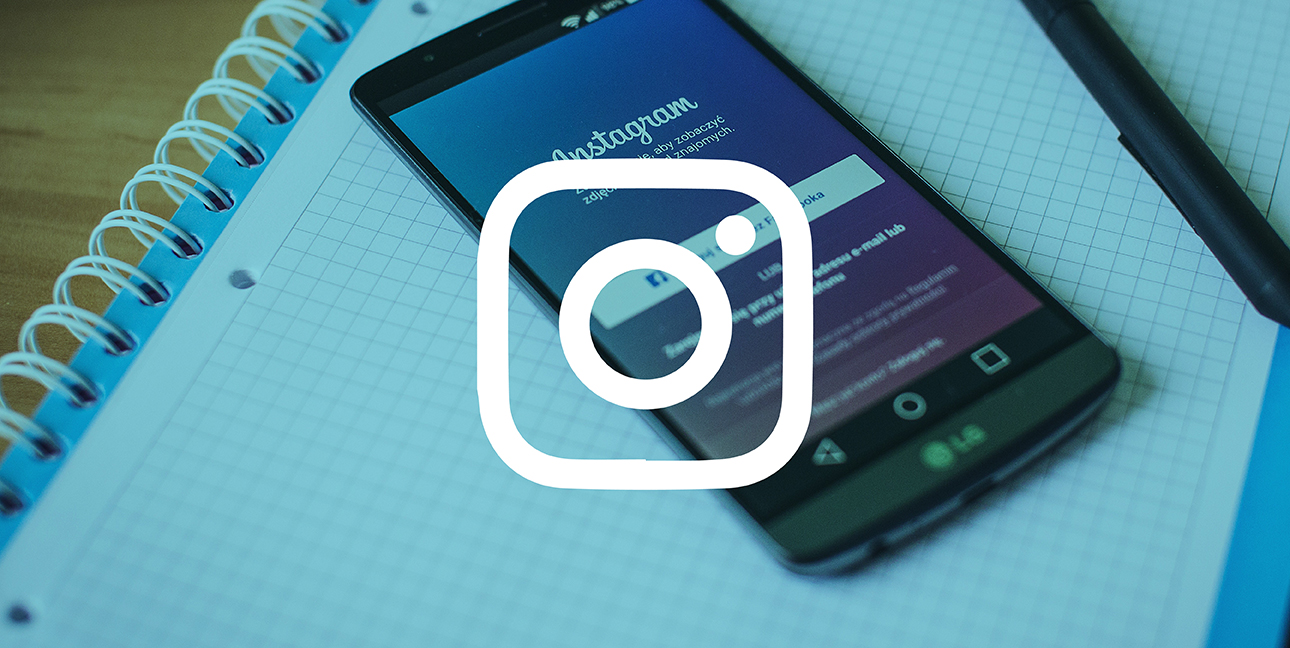 A phone sits on top of graph paper as it displays the login screen for Instagram.