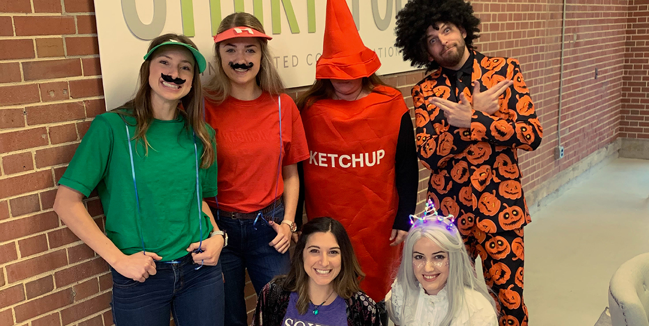 A picture of the 8THIRTYFOUR team wearing all of their 2019 Halloween costumes.