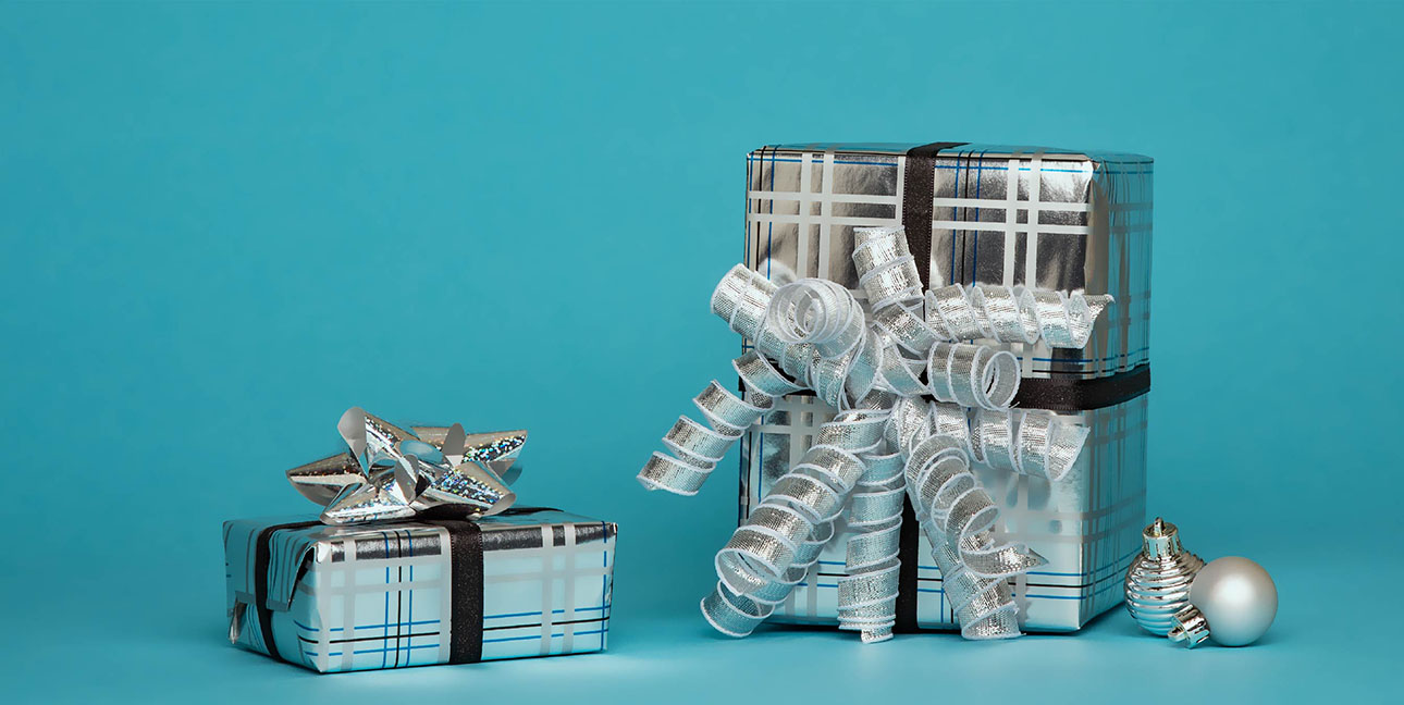 An image of silver wrapped presents against a blue background.