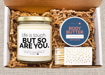 A care box with a candle and body butter.