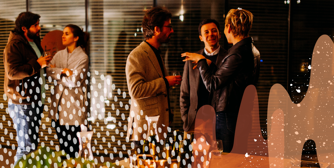 Two men and one woman talking closely at a networking event in the evening