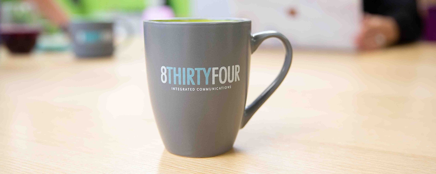 An 8THIRTYFOUR mug rests on a table in the office.