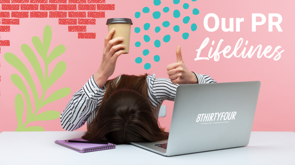A young woman holding a coffee above her head while she rests it on the table in front of a lap top "Our PR Life Lines"
