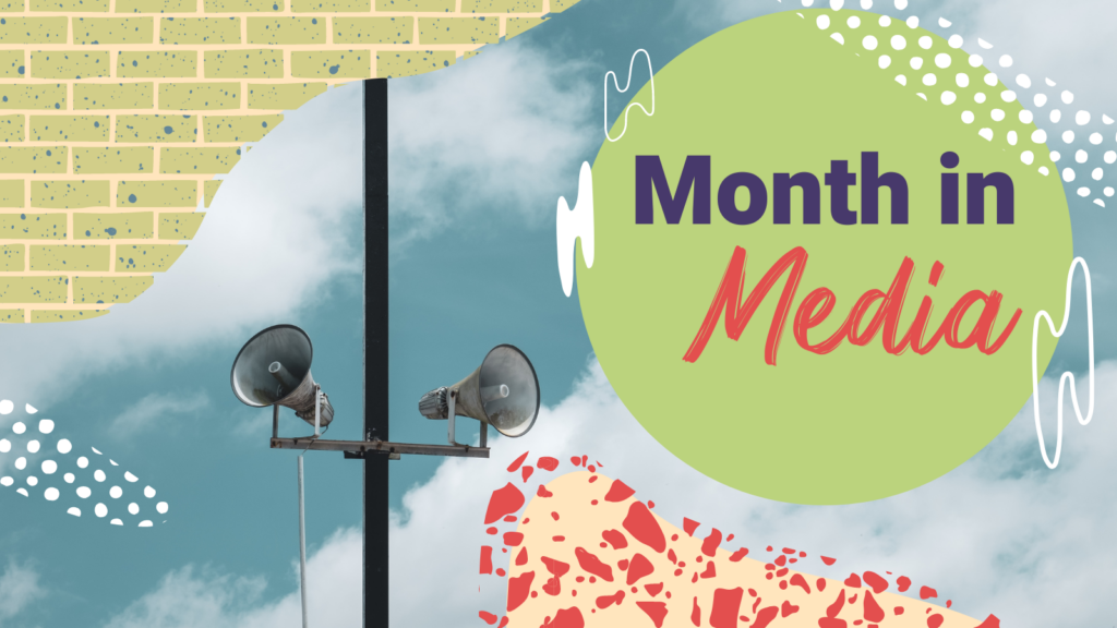 A pair of speakers hang attached from a metal pole "Month in Media"