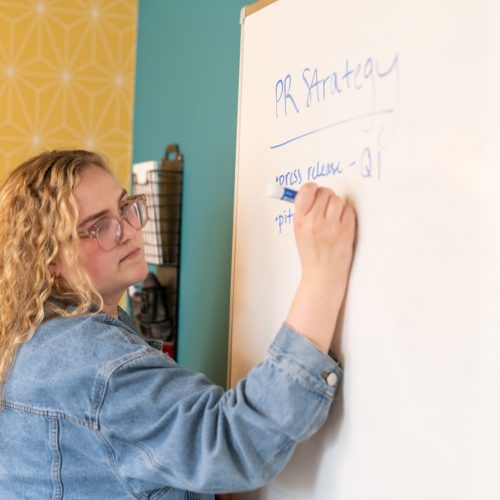 Emma Writes about PR strategy on a whiteboard